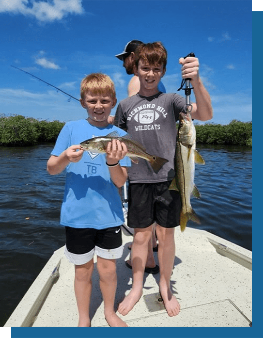 Noah and Conor Holding a Redfish and a Snook